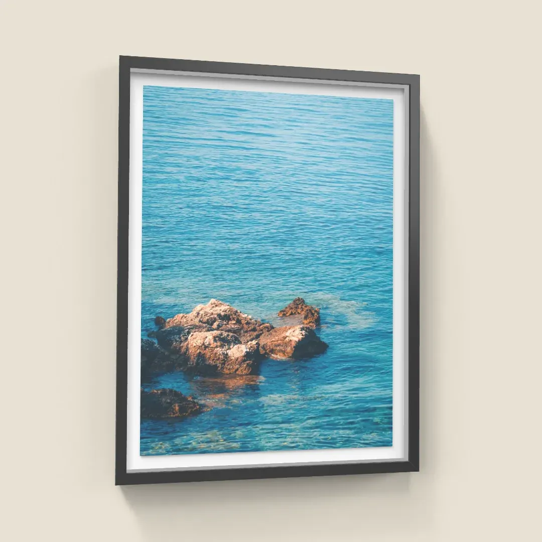 Seascape photograph of rocks in a glossy black floating box frame
